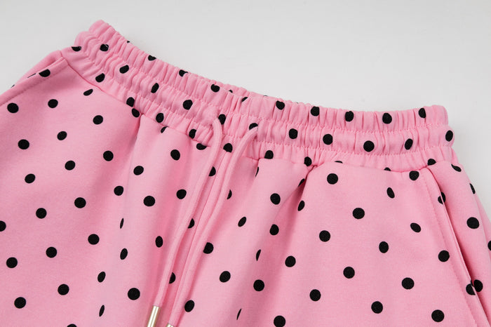 Close-up of the pink polka dot sweatpants waistband and front pocket opening