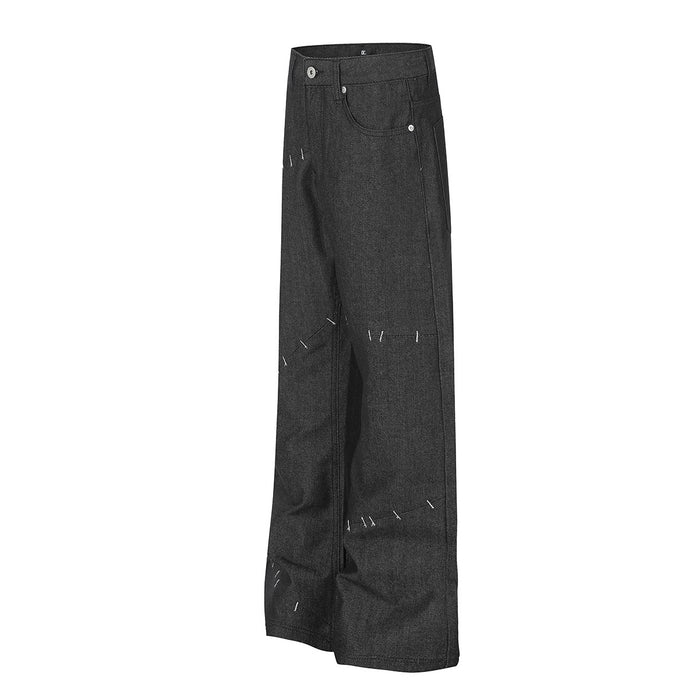 Angled front view of black wide-leg denim jeans with contrast stitch details across the legs