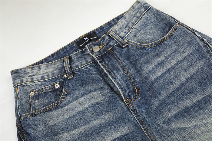 Close-up of the jeans waistband, belt loops, front pockets, button, and faded blue denim