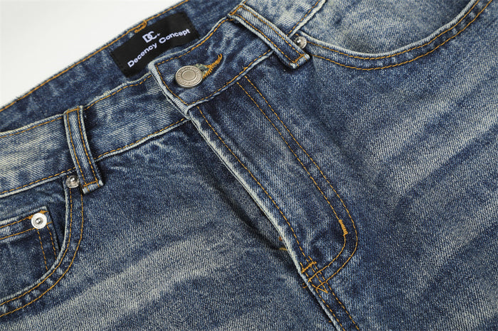 Detailed close-up of the jeans button closure, belt loop, stitched fly, and washed denim texture
