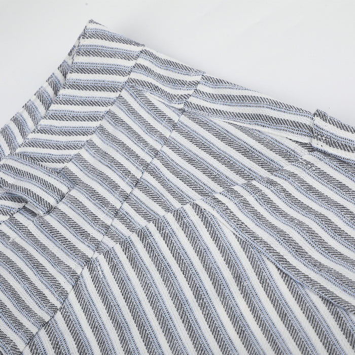 Close-up of trouser waistband construction with intersecting seams and directional gray-white stripes
