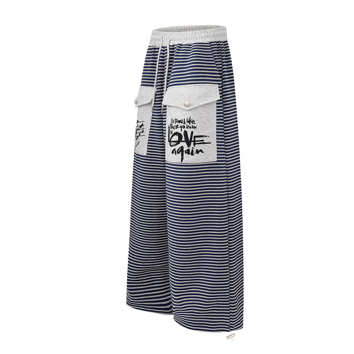 Angled front view of navy and white striped wide-leg sweatpants with gray flap cargo pockets and drawstring waist
