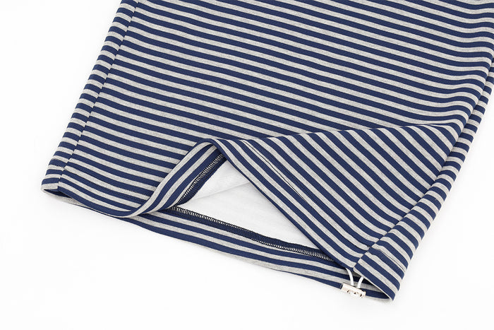 Close-up of the striped pant leg hem showing a side zipper opening and light inner lining