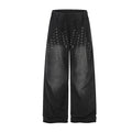 Washed black wide-leg sweatpants with scattered metal eyelet grommet detail on front thighs, elastic waistband, straight cut