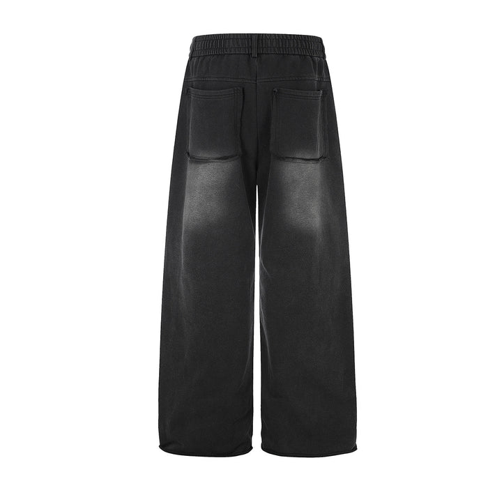 Back view of black wide-leg sweatpants with two large rounded patch pockets and relaxed straight-cut legs