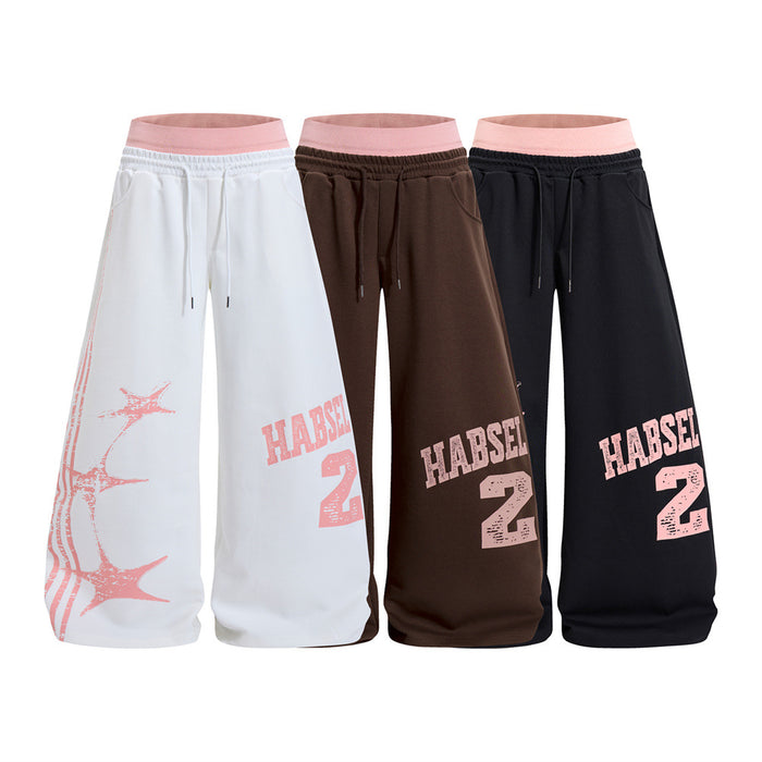 Three pairs of wide-leg sweatpants in white, brown, and black with pink double waistbands and distressed graphics