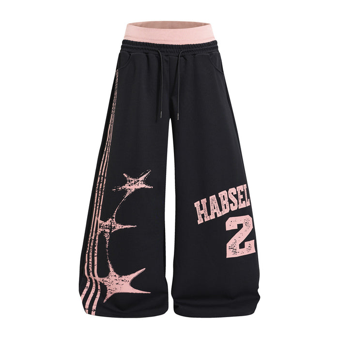 Black wide-leg sweatpants with a pink double waistband, distressed star print, and pink numbered front graphic