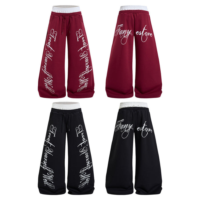 Front and back views of burgundy and black wide-leg sweatpants with white waistbands and cursive lettering