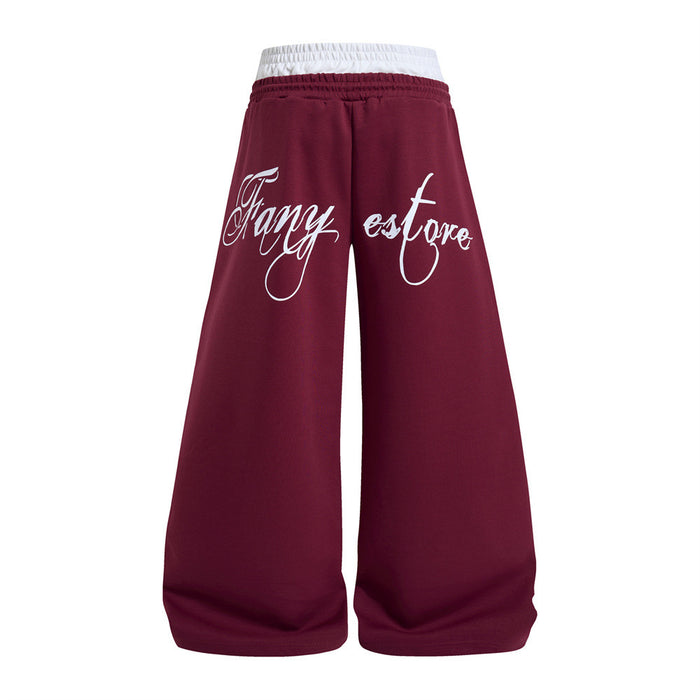 Back view of burgundy wide-leg sweatpants with a white contrast waistband and large white cursive lettering