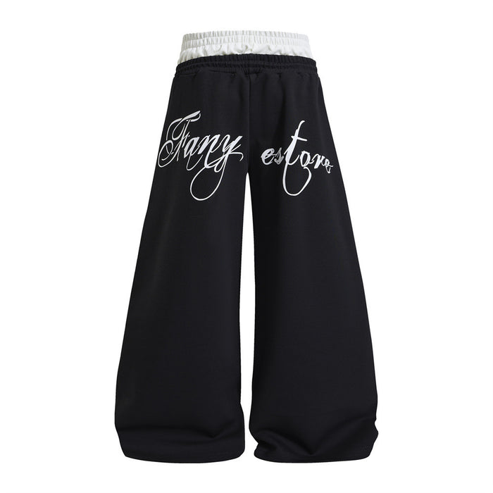 Back view of black wide-leg sweatpants with a white contrast waistband and white cursive lettering