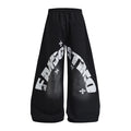 Black wide-leg sweatpants shown from the back with large distressed white arched lettering and star graphics