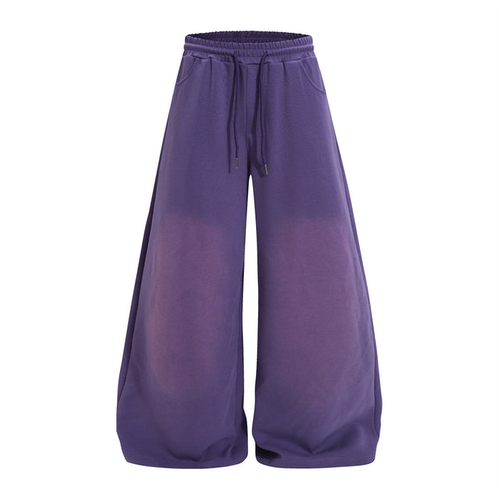 Purple wide-leg sweatpants shown from the front with elastic waistband, drawstring, side pockets, and faded leg panels