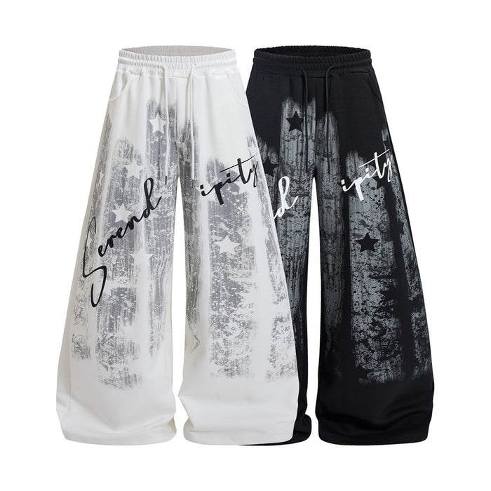 White and black wide-leg sweatpants shown from the front with grunge star graphics and Serendipity script