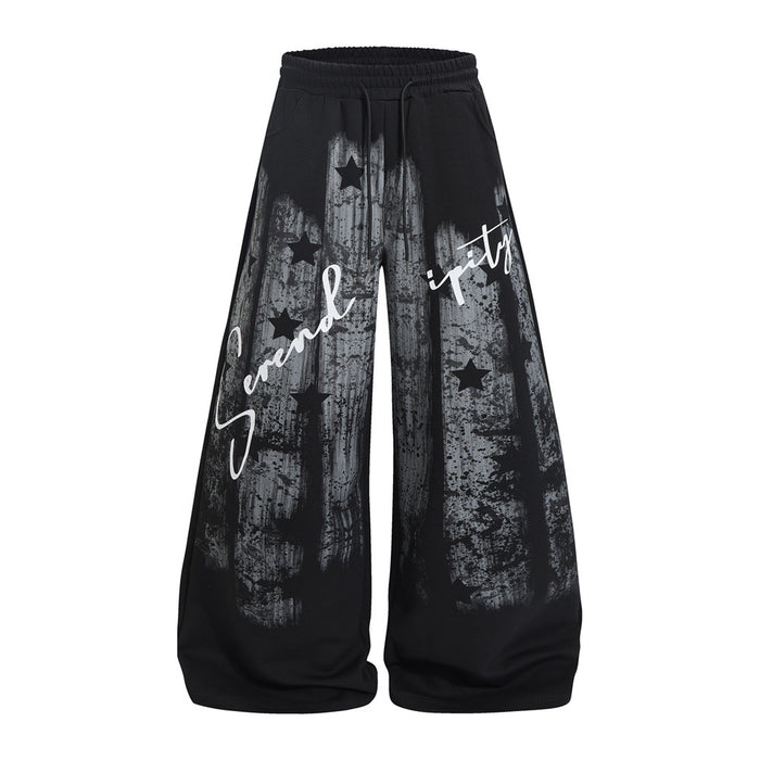 Black wide-leg sweatpants shown from the front with distressed gray star graphics and white Serendipity script