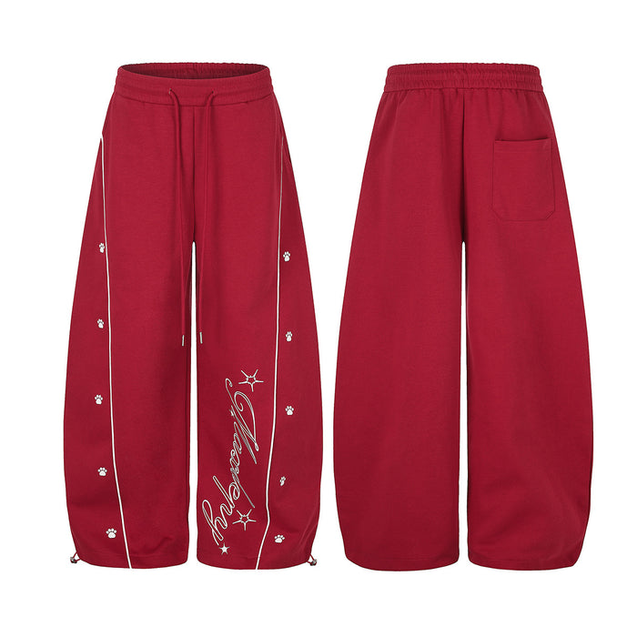Red wide-leg sweatpants shown from front and back with white piping, paw prints, script graphic, and rear pocket