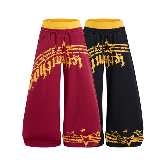 Front view of burgundy and black wide-leg sweatpants with yellow waistbands and star graphic prints
