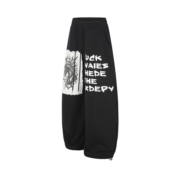 Angled front view of black wide-leg sweatpants with a white animal patch and graffiti-style lettering