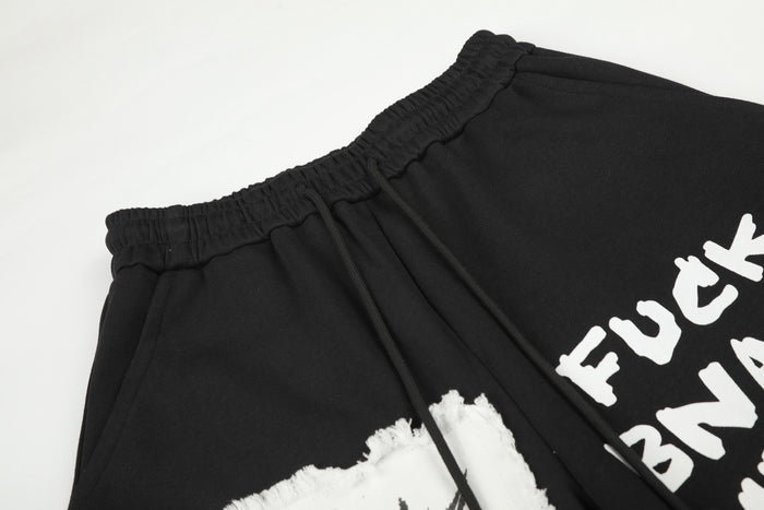 Close-up of the black sweatpants waistband, drawstrings, side pocket, and partial white graphic