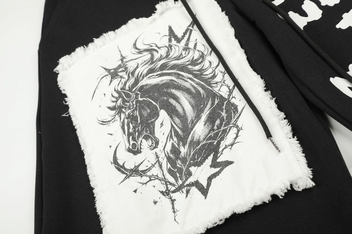 Close-up of a frayed white patch featuring a detailed black animal illustration on the sweatpants