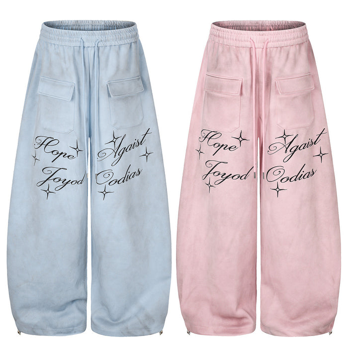 Front view of wide-leg velour sweatpants in light blue and pink with script lettering and cargo pockets