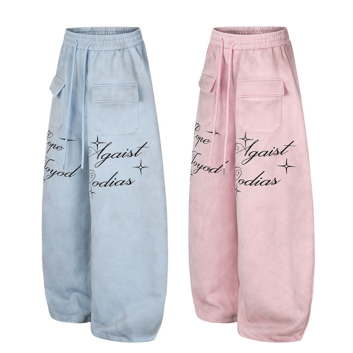 Angled front view of light blue and pink wide-leg sweatpants with cargo pockets and script print