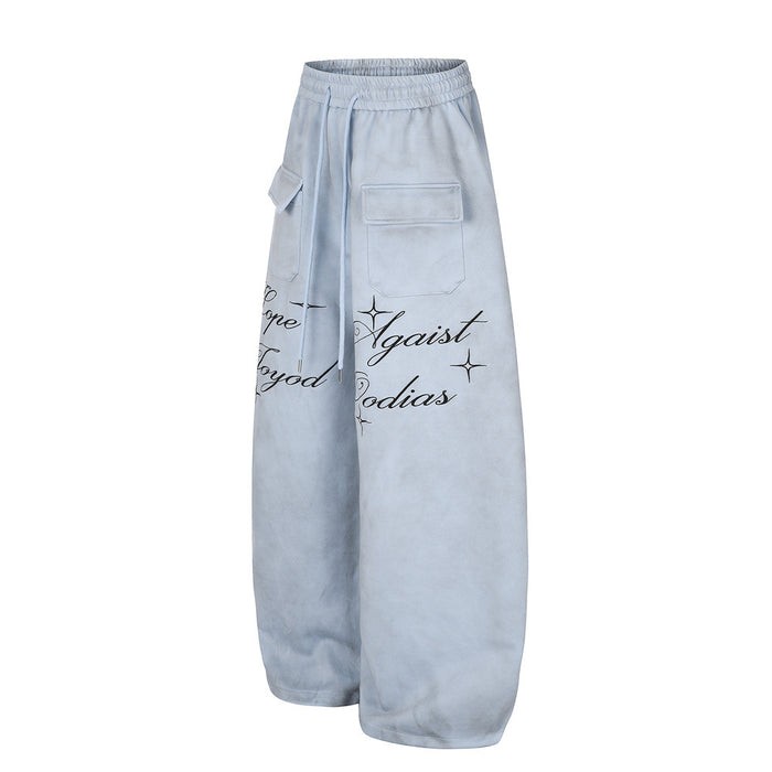 Angled front view of light blue wide-leg sweatpants with cargo pocket, drawstring, and script lettering