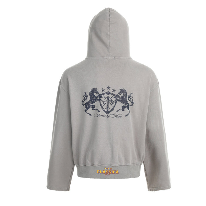 Back view of the light gray cropped hoodie with a large dark heraldic crest graphic and hem label