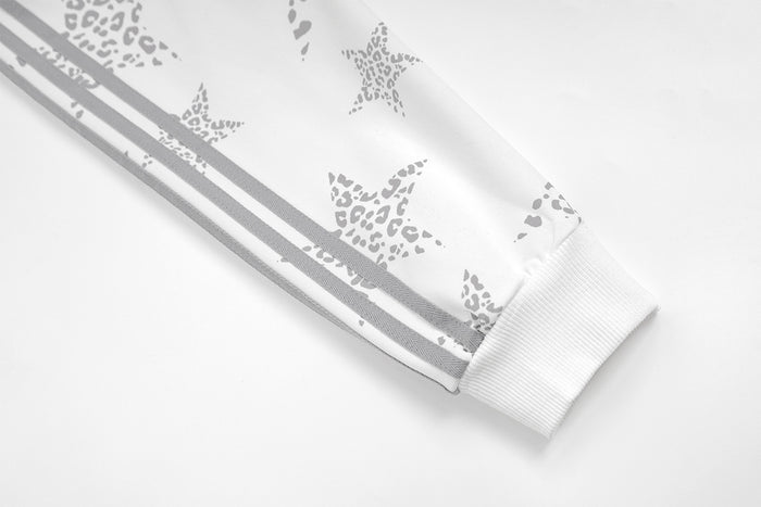 Close-up of a white ribbed sleeve cuff with gray side stripes and star print
