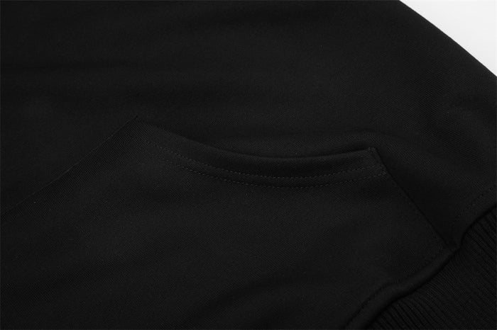 Close-up of the black hoodie’s front kangaroo pocket with visible curved pocket opening