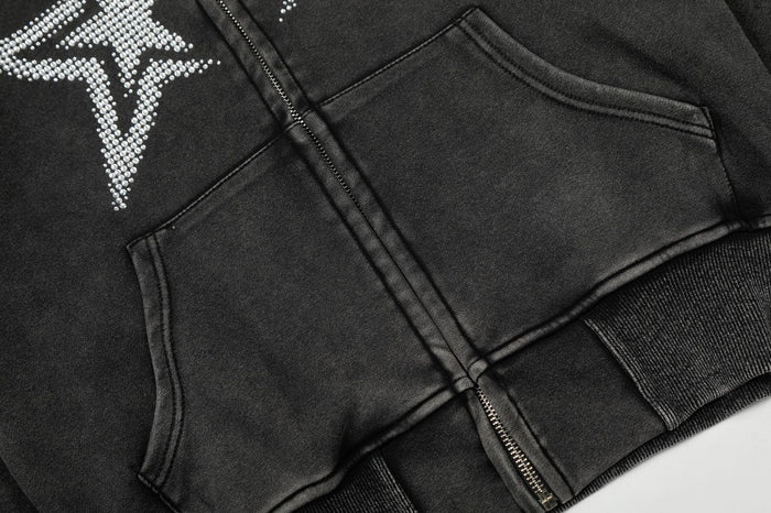 Close-up of the black hoodie front showing the kangaroo pocket, zipper, star graphic, and ribbed hem